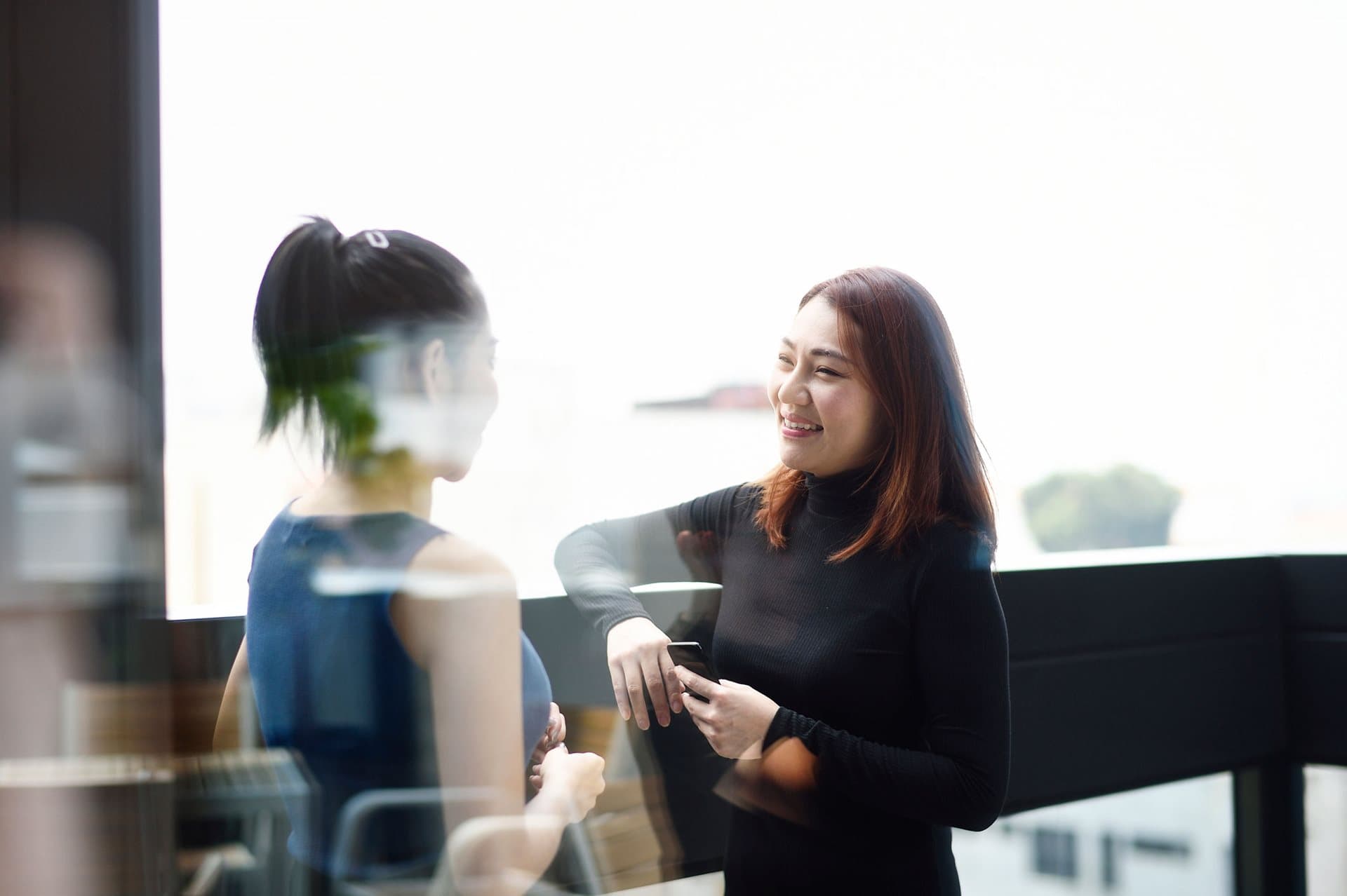 Two woman talking with each other in the workplace