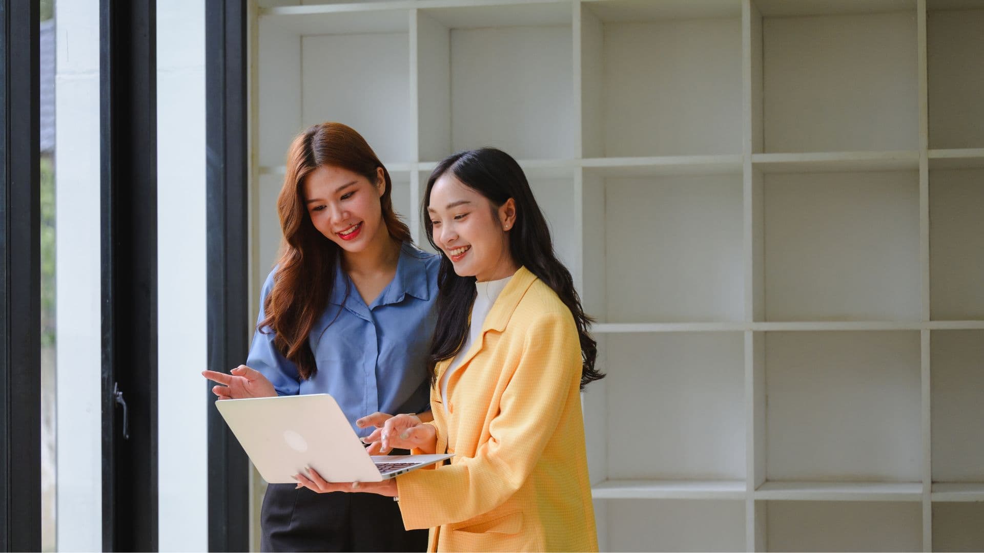 Two young graduates looking at a laptop
